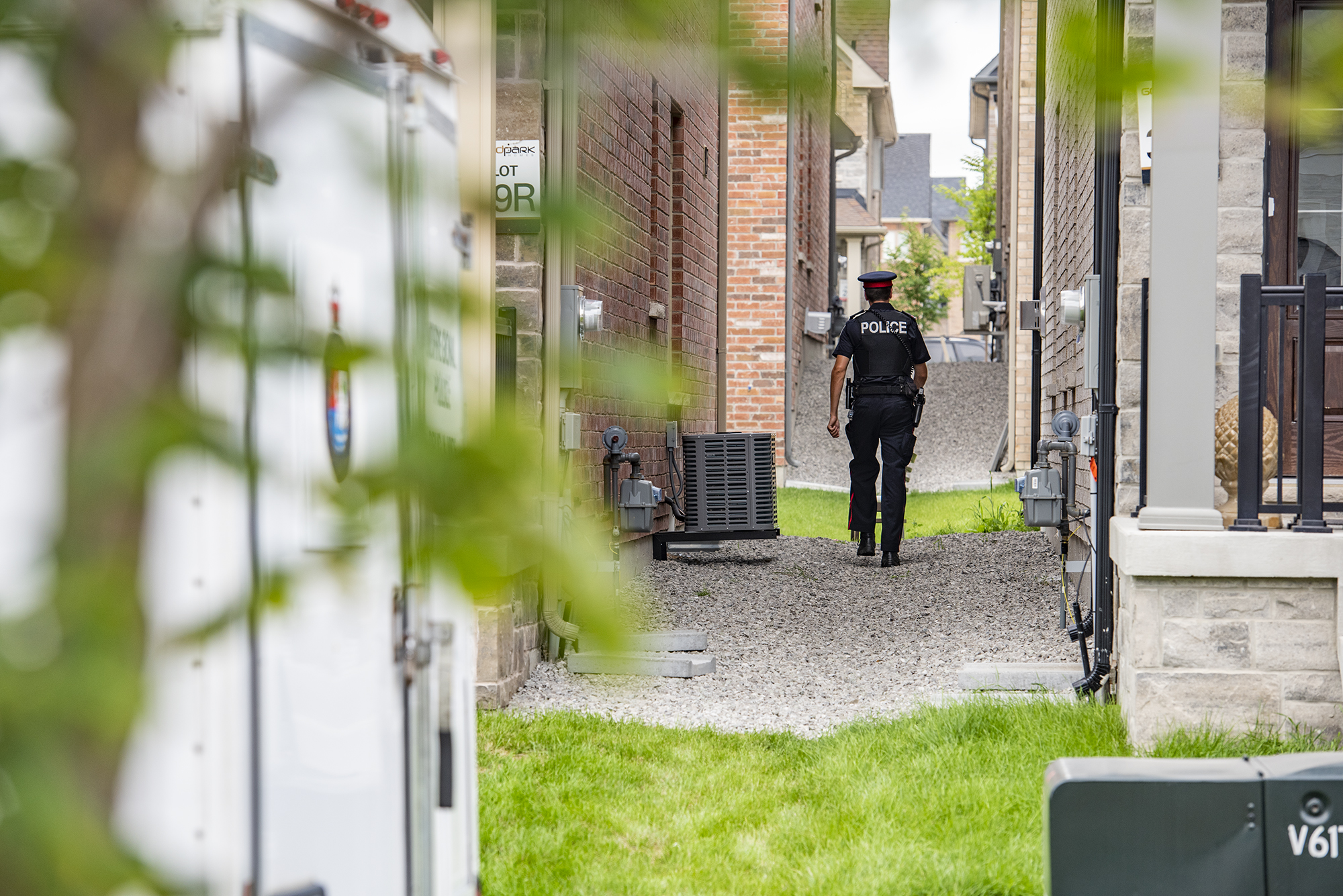 A person in a police uniform walks between two houses