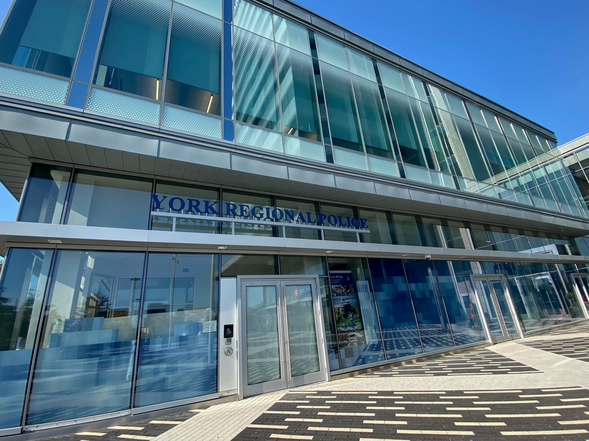 The exterior of a building, with glass windows and doors and a sign reading "YORK REGIONAL POLICE"